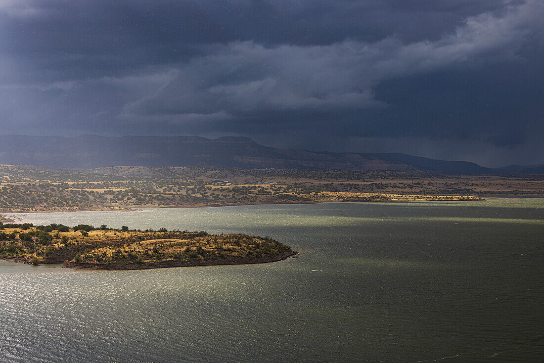 Usa, New Mexico, Abiquiu, Sonne scheint durch Gewitterwolken über dem Abiquiu-See