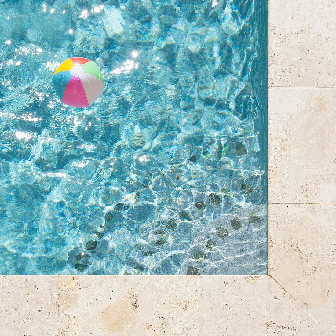 Beach ball floating in swimming pool
