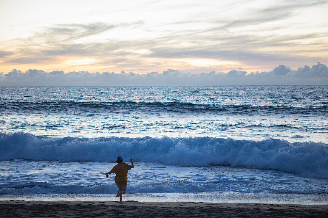 Mexiko, Baja, Pescadero, Silhouette eines Jungen am Strand in der Abenddämmerung