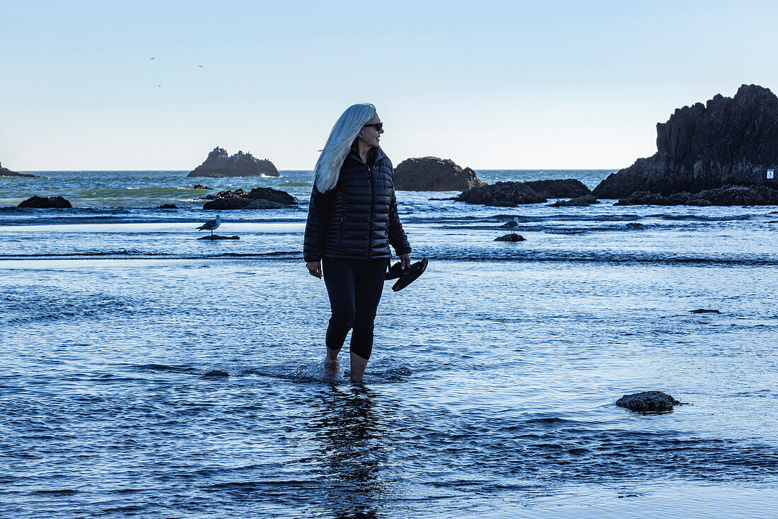 USA, Oregon, Woman wading in ocean at Cannon Beach 