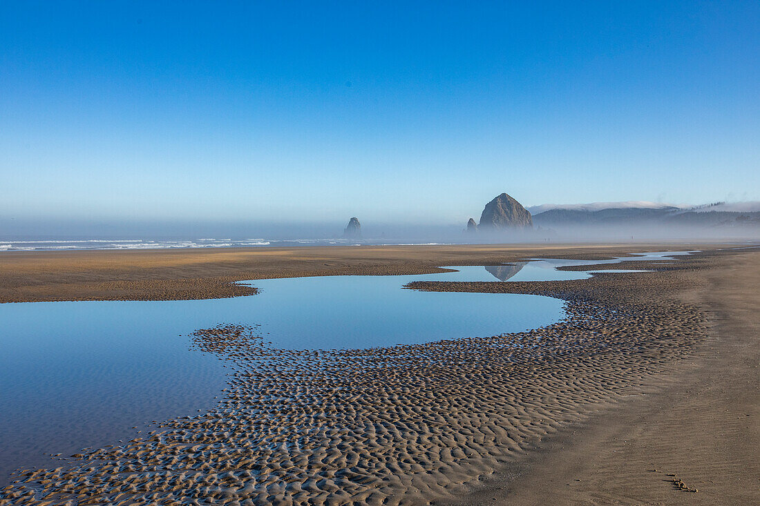 USA, Oregon, Flache Wassertümpel am sandigen Cannon Beach