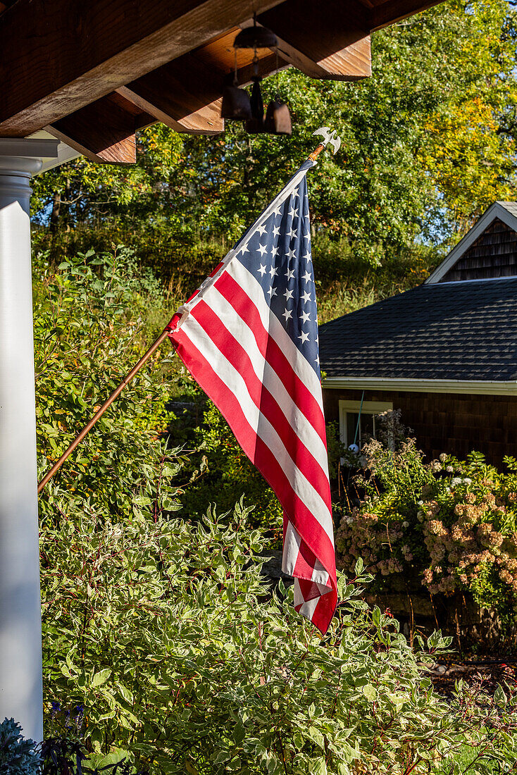 American flag outside house in sunlight