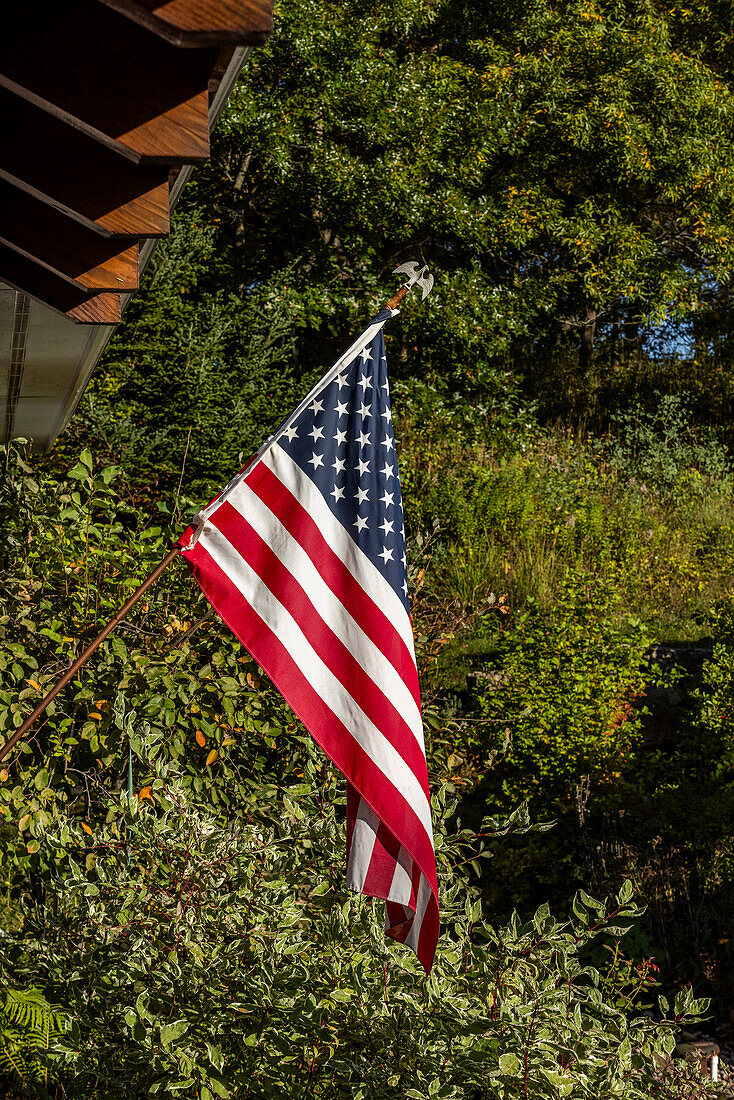 American flag outside house in sunlight