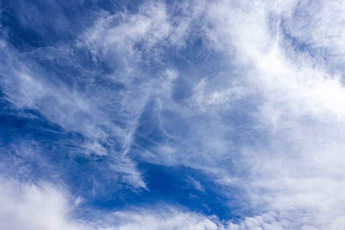 Hauchdünne weiße Wolken am blauen Himmel