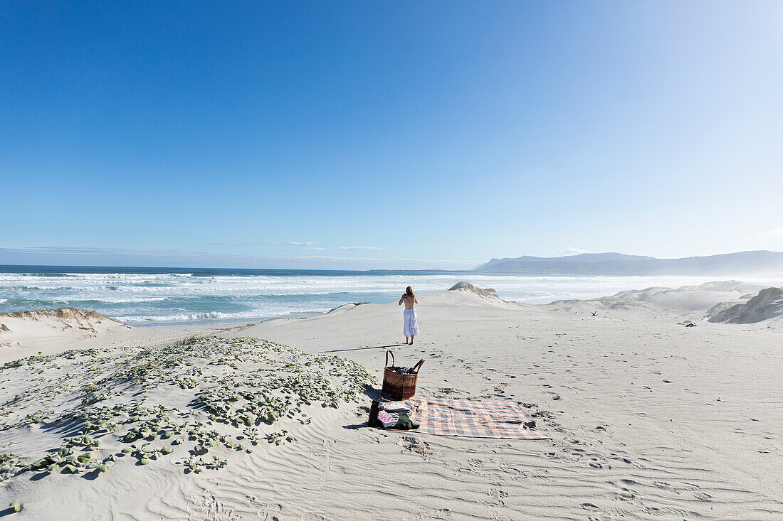 Teenage girl (16-17) having picnic on beach in Walker Bay Nature Reserve