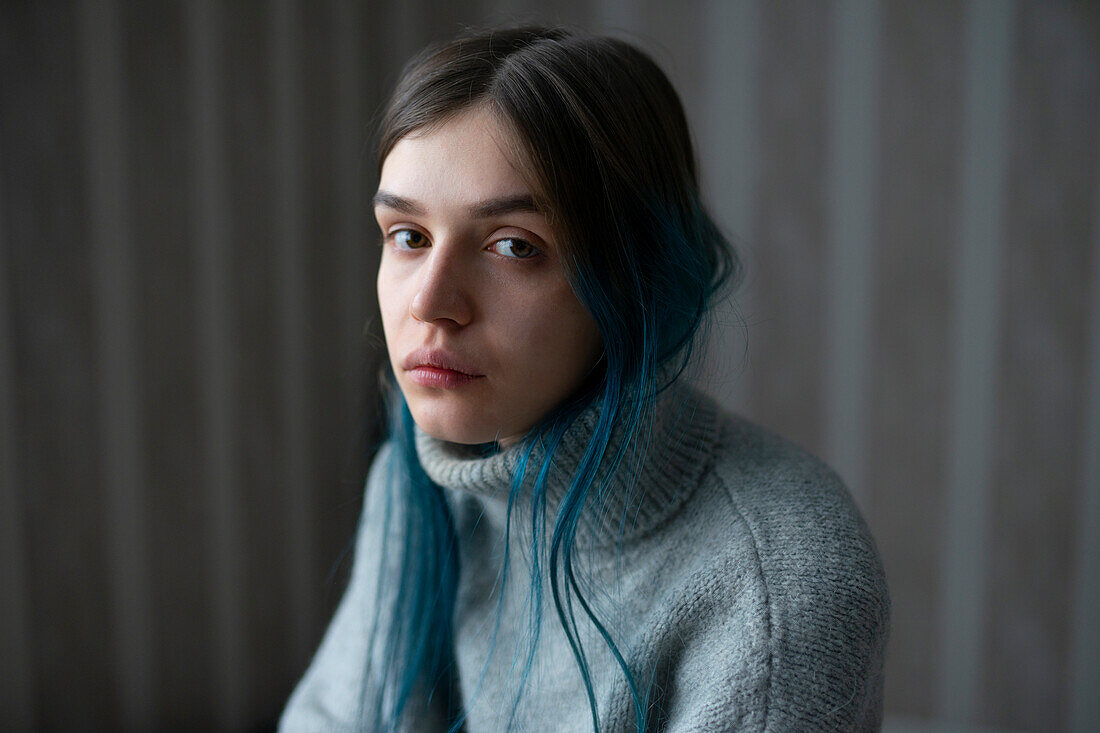 Portrait of serious woman in gray sweater