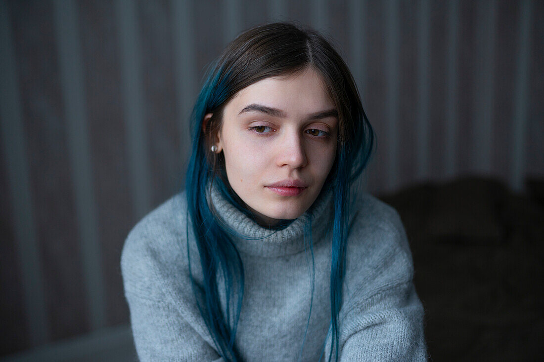 Portrait of serious woman in gray sweater