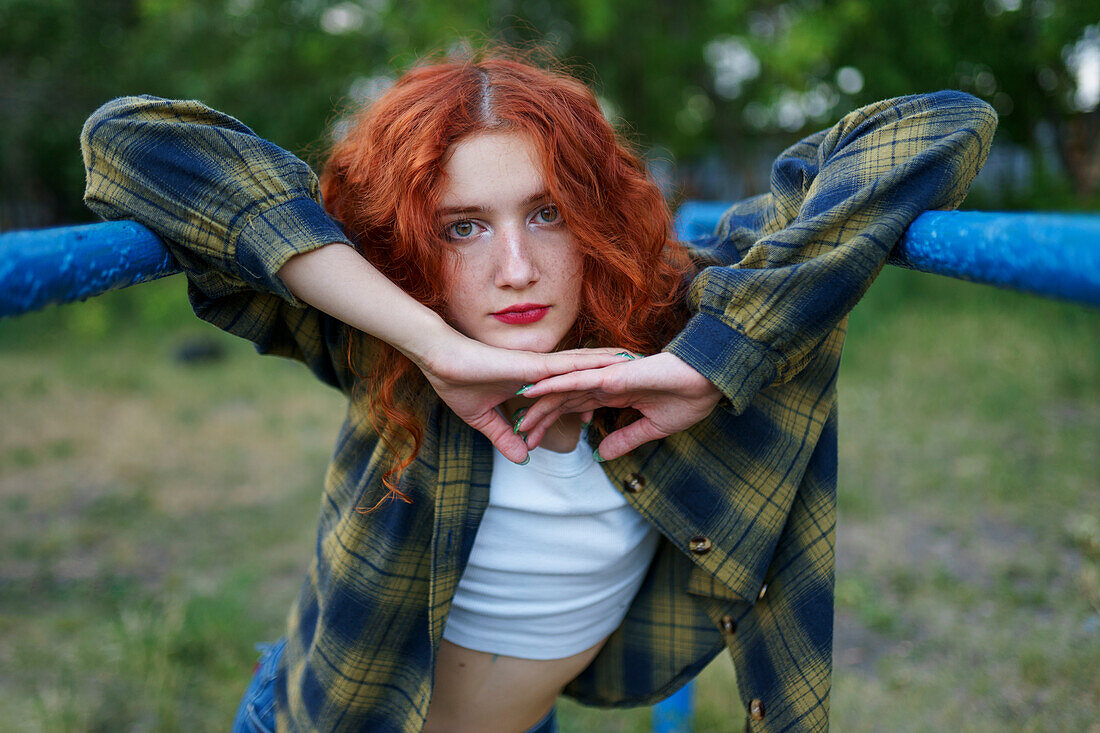 Redhaired woman posing at playground