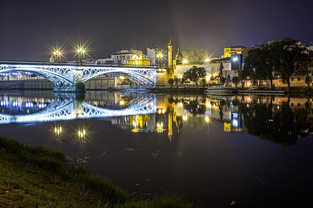 Nächtliche Ansicht der Triana-Brücke und der Capillita Del Carmen