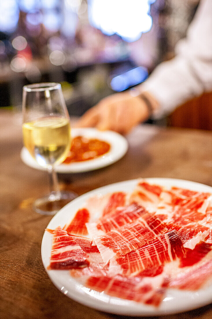 Ein Glas Fino und iberischer Schinken in einer Taverne in Sevilla