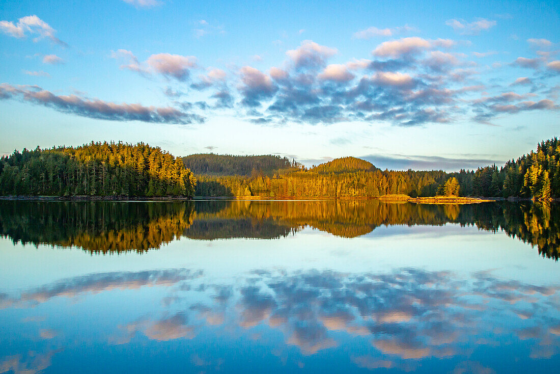 Canada, British Columbia, Inside Passage. Sunrise on ocean and forested hills.