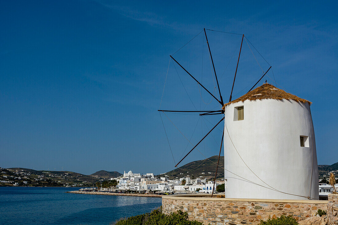 Ein malerischer Blick auf das Hafenviertel von Parikia und eine traditionelle Windmühle. Parikia, Insel Paros, Kykladeninseln, Griechenland.