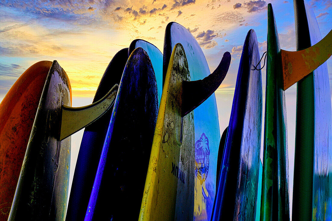 Gestapelte Surfbretter bei Sonnenuntergang nach einem Tag in der Surfschule in Canggu, Bali, Indonesien