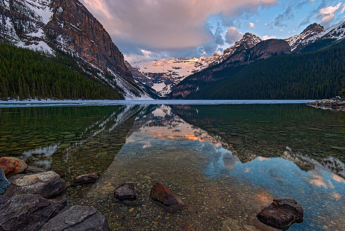 Canada, Alberta, Banff National Park. Sunrise reflections on calm Lake Louise.