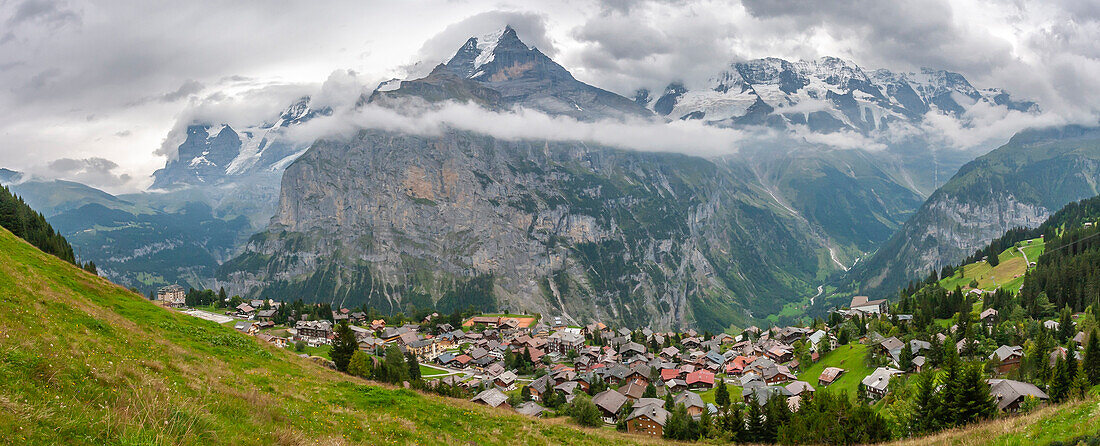 Europa, Schweiz, Berner Oberland. Panoramablick auf Berge und Dorf im Tal.