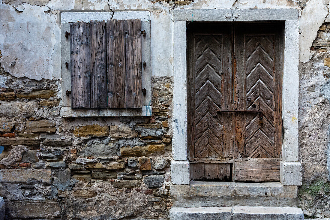 A view of a wooden door and shuttered window. Isola, Slovenia.