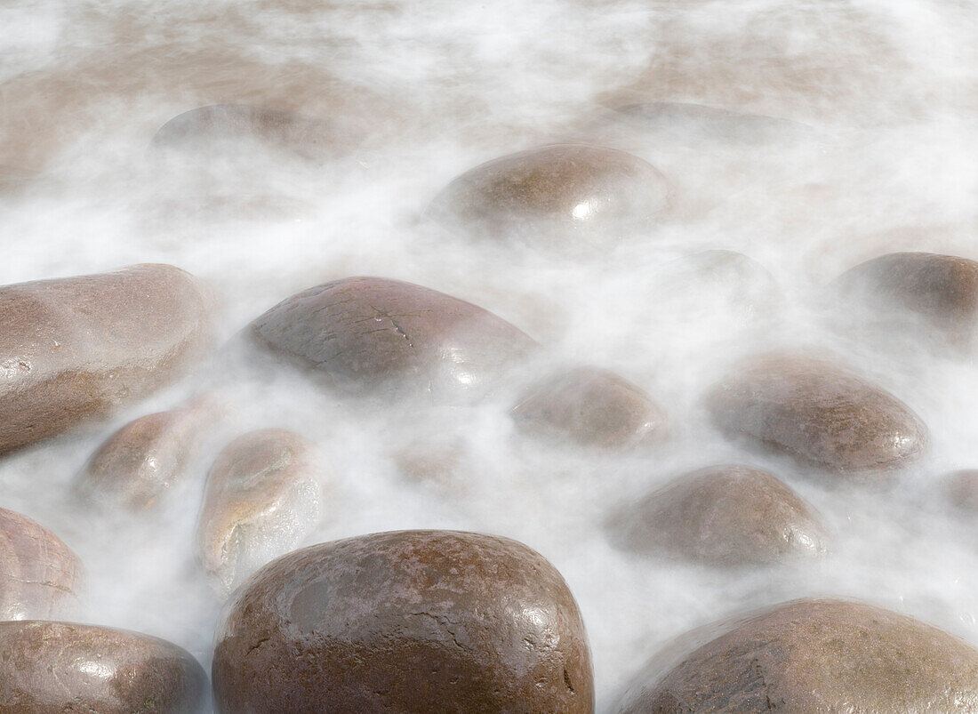 Irland, Kinard. Nahaufnahme einer Welle auf glatten Strandfelsen.