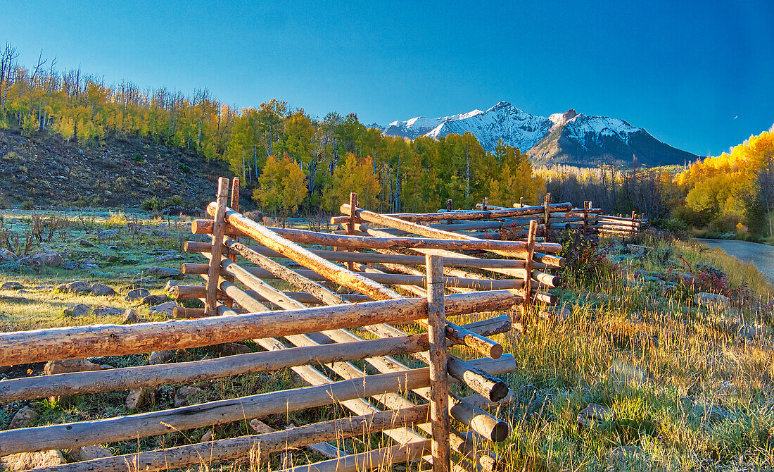 USA, Colorado, Quray. Dallas Divide, Sonnenaufgang auf dem Mt. Snaffles mit Herbstfarben und Split Rail Zaun