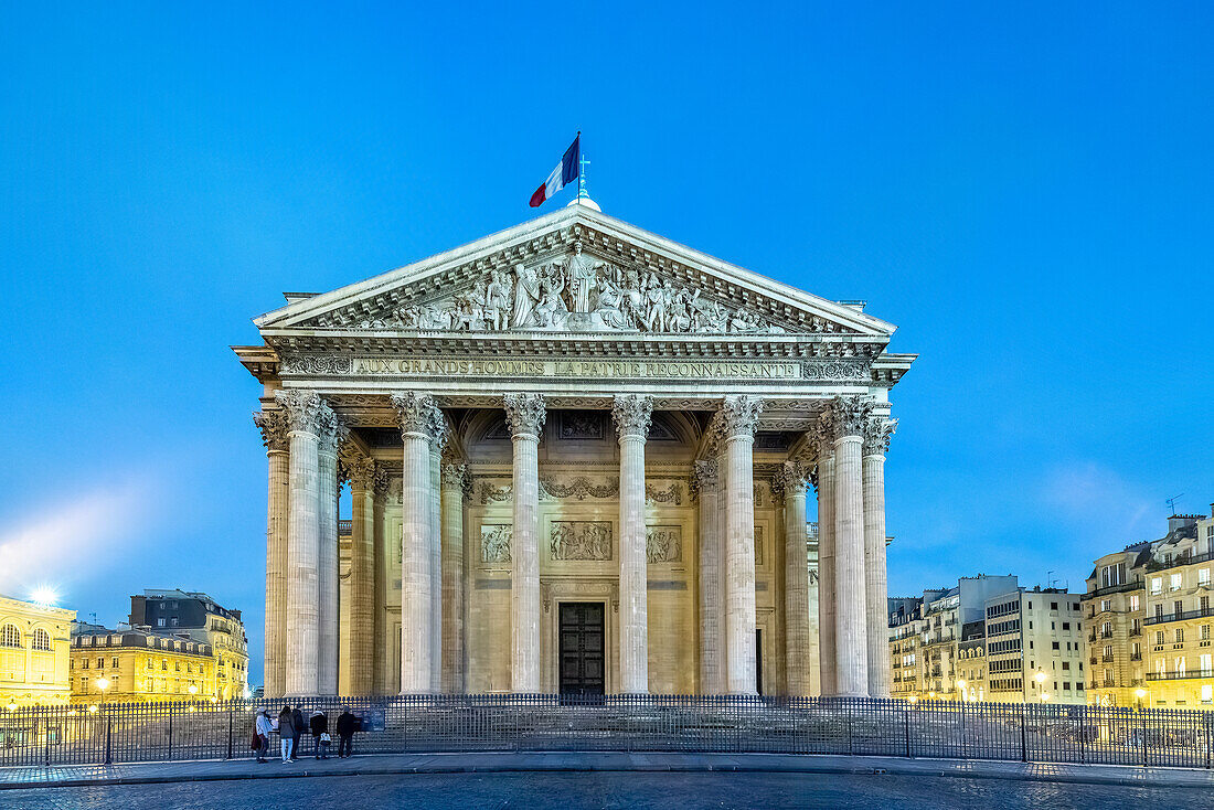 Die neoklassizistische Fassade des Panthéon ist in der Abenddämmerung beleuchtet.