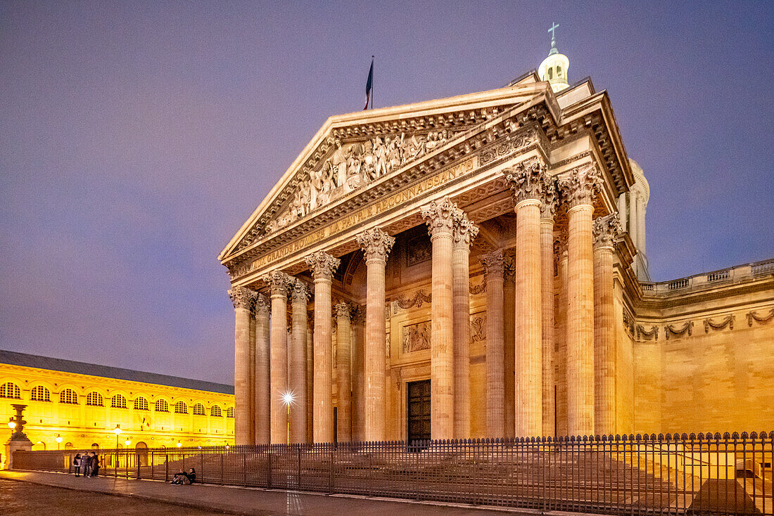 Die neoklassizistische Fassade des Panthéon ist in der Abenddämmerung beleuchtet.