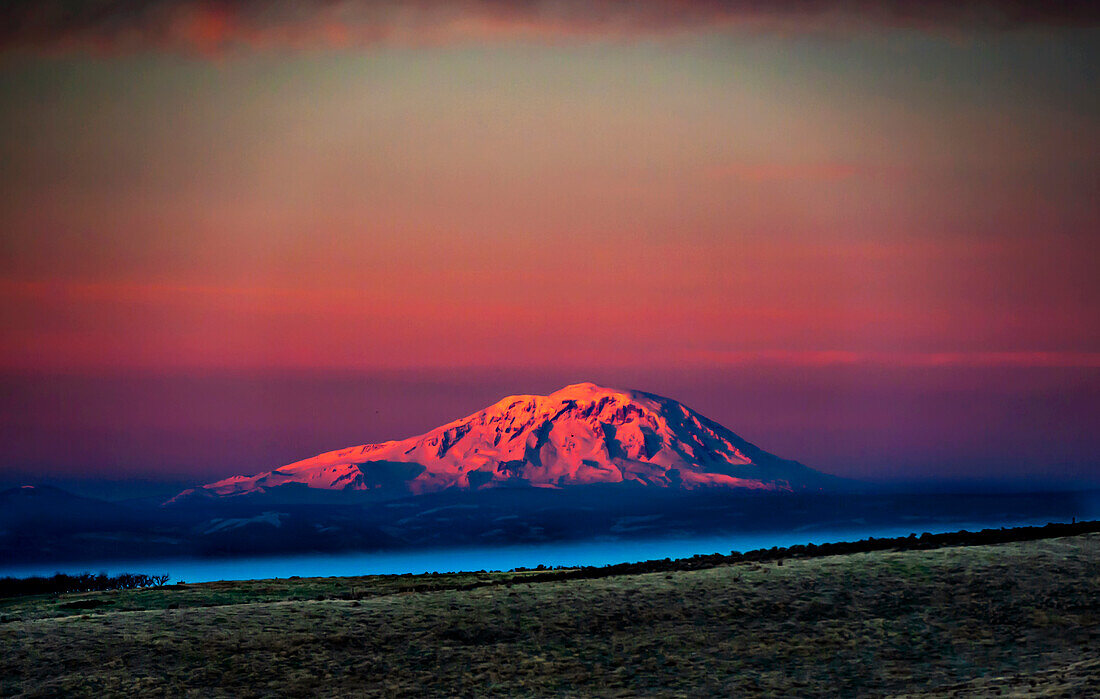 USA, Bundesstaat Washington, Zillah. Morgendämmerung auf dem Berg Adams, gesehen vom Yakima Valley Weinland im Winter.