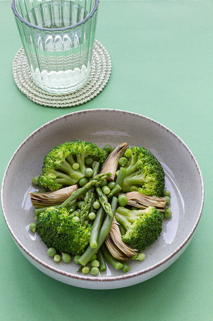 Closeup viewed from above of a vegetable dish with broccoli, mushrooms and peas