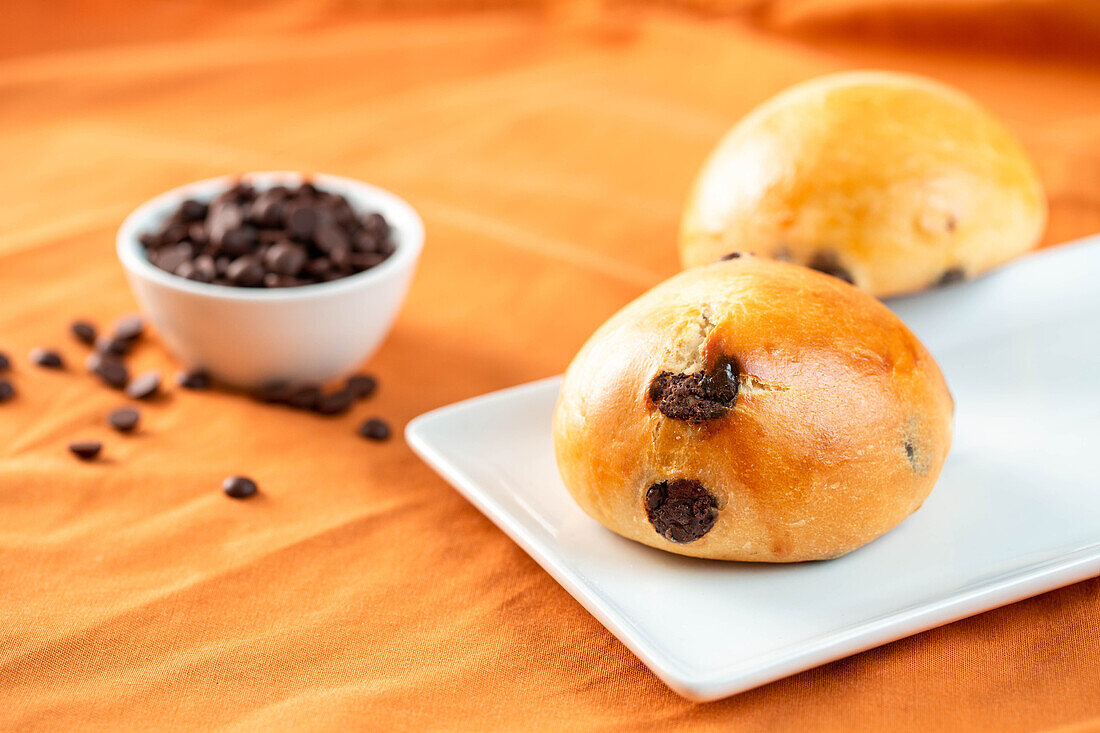 Frische Schokobrötchen zum Frühstück auf einem Teller und einem Tisch am Morgen