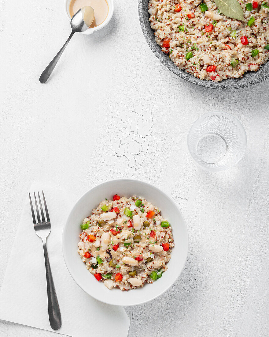 Nahaufnahme von mehreren Tellern mit Bulgur-Quinoa-Bohnen auf einem weißen Tisch