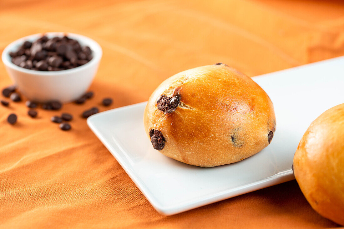 Frische Schokobrötchen zum Frühstück auf einem Teller und einem Tisch am Morgen