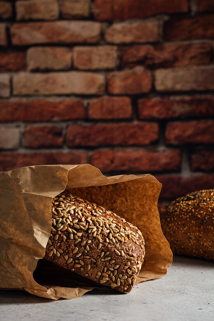 Leckeres Vollkornbrot mit brauner Kruste und Sonnenblumenkernen auf einem Tisch bei Tageslicht