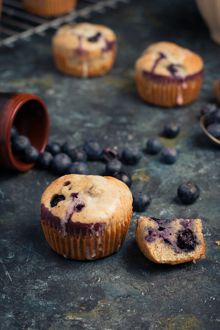 Blick von oben auf süße hausgemachte Muffins mit Sahne und Blaubeeren auf dem Tisch