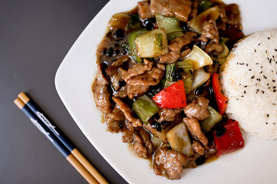 Top view of dish with beef in delicious oyster sauce and chopsticks in restaurant