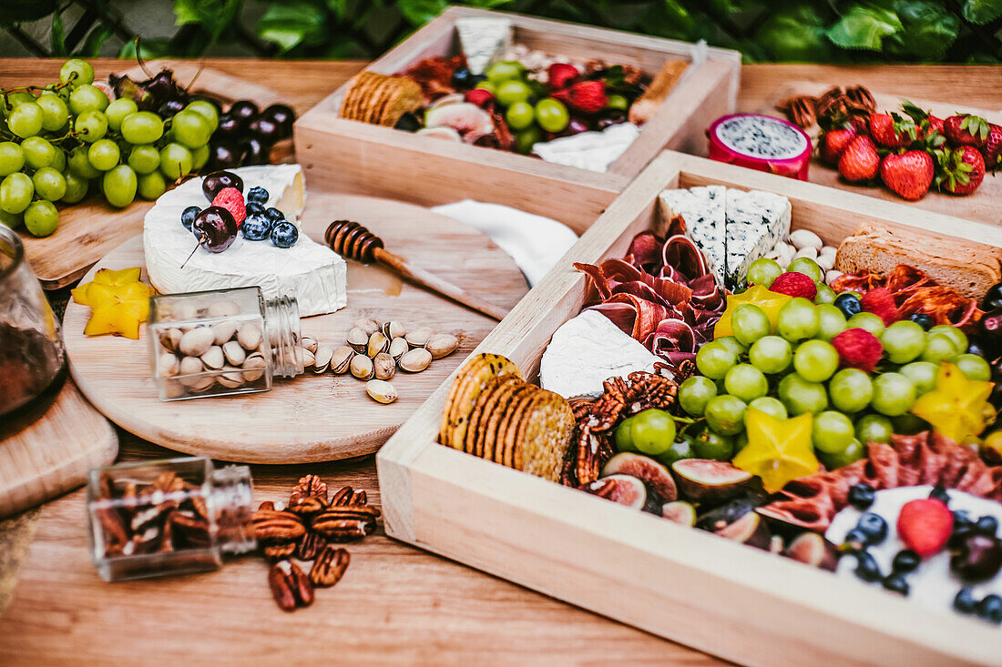 Draufsicht auf köstliche frische Häppchen auf Holztisch neben grünem üppigen Strauch