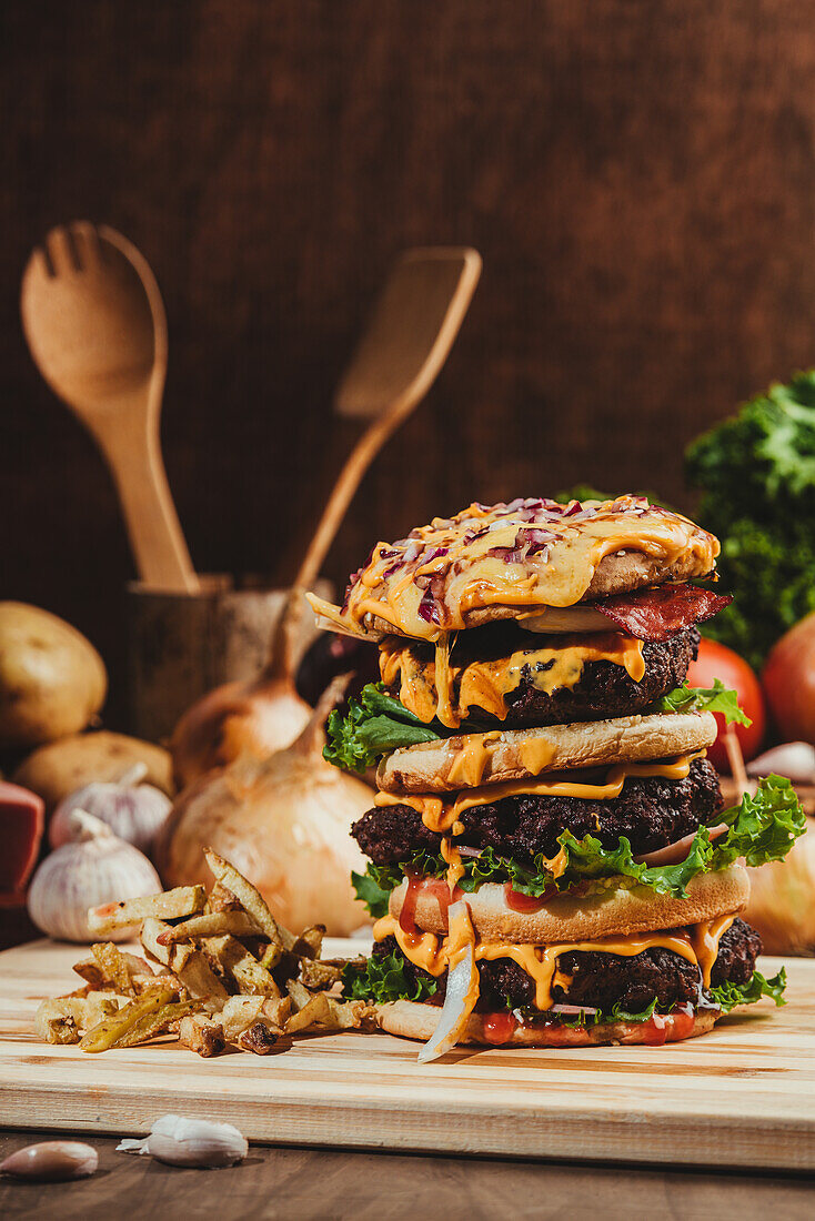 Appetitliche Hamburger mit Gemüse auf Holzbrett mit Pommes frites in Küche