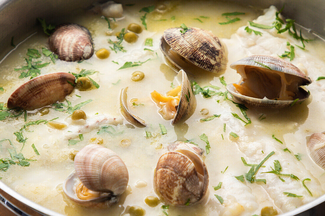 Von oben Metalltopf mit köstlicher Meeresfrüchtesuppe mit Muscheln und Seehecht