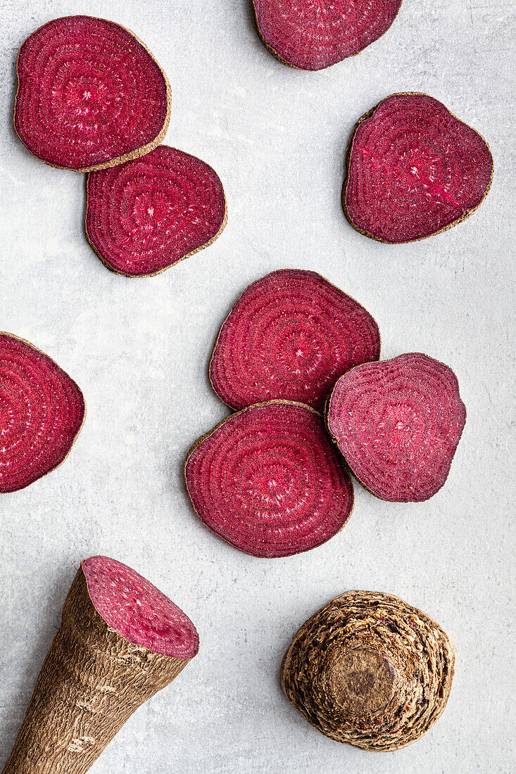 Overhead composition of organic natural beetroot cut into slices and arranged on white surface