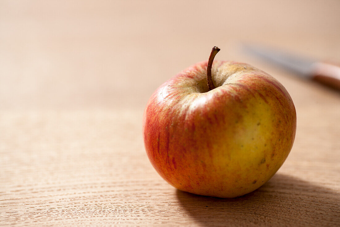 Einzelner Apfel auf Holztisch