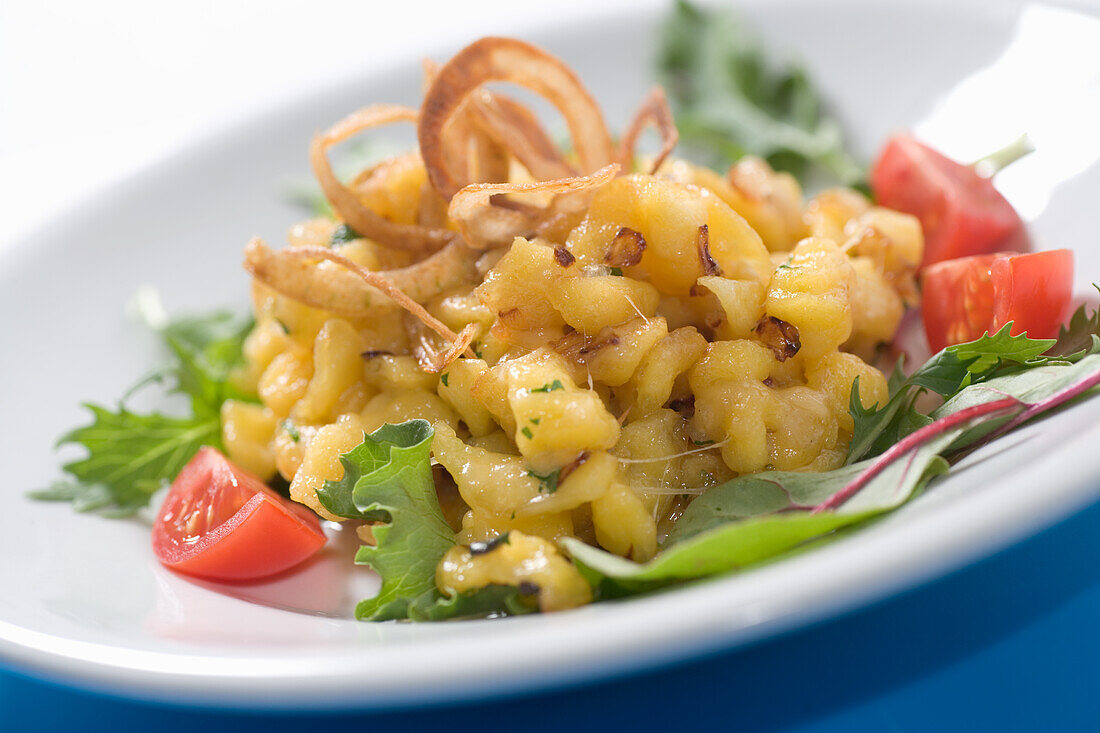 Cheese spaetzle with roasted onions, lettuce and tomatoes