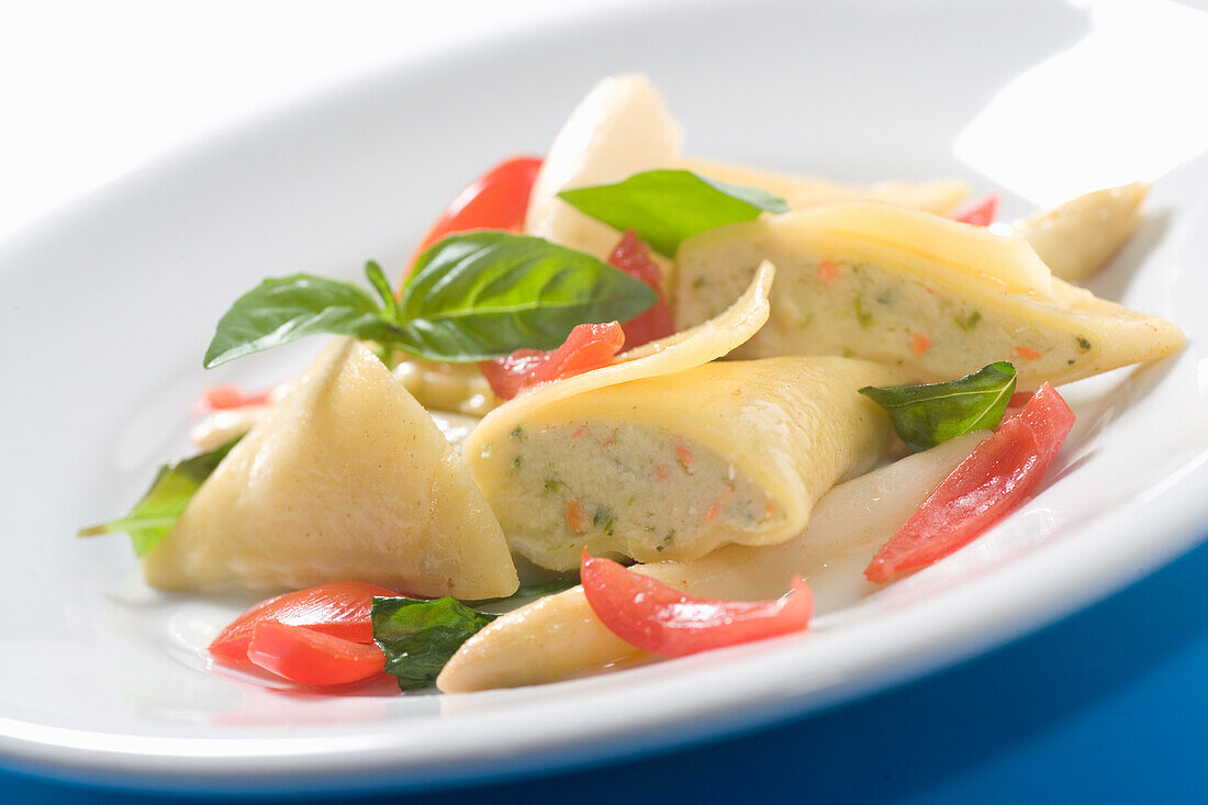 Maultaschen mit Tomaten auf weißem Spargel