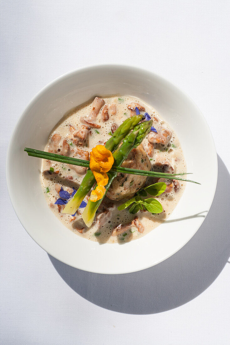 Chanterelles in herb cream with bread dumplings and asparagus