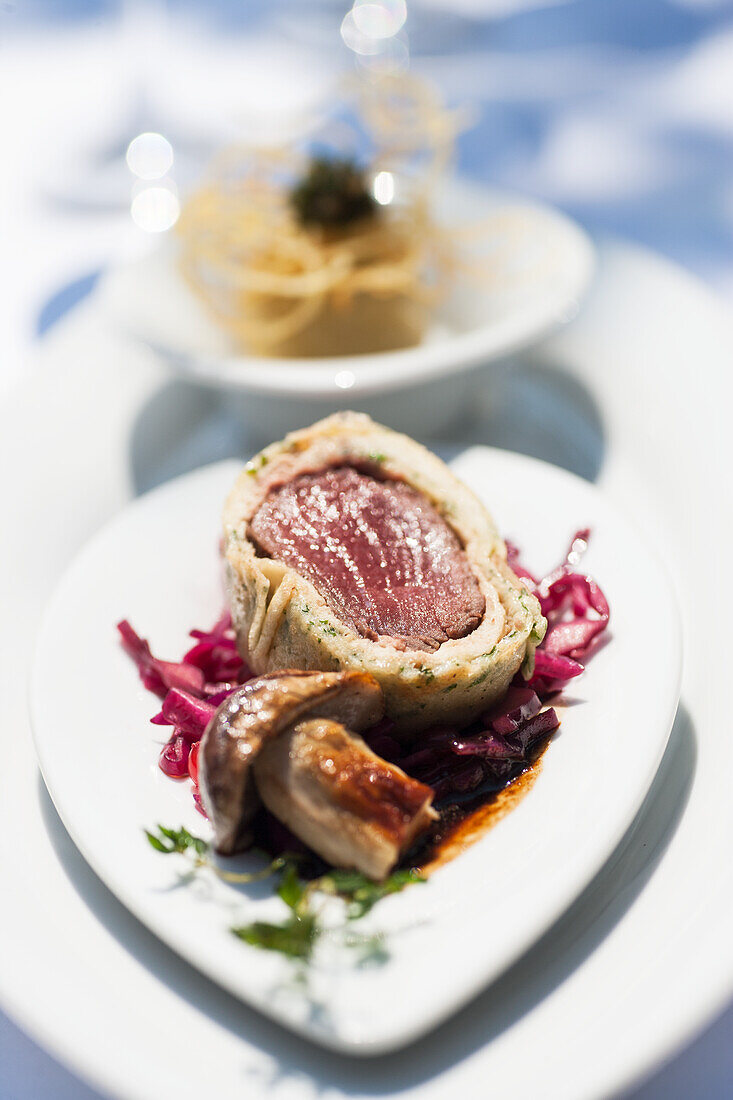 Saddle of venison wrapped in pastry with herbs and garnish