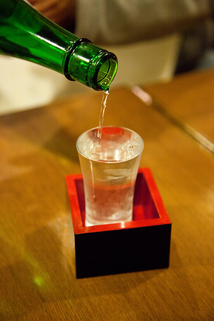 Pouring sake into a traditional glass