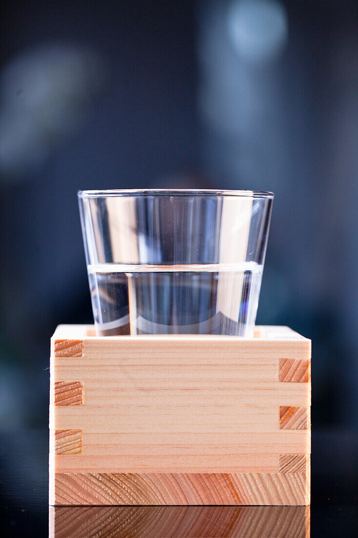 Sake im Glas auf traditioneller Holzbox