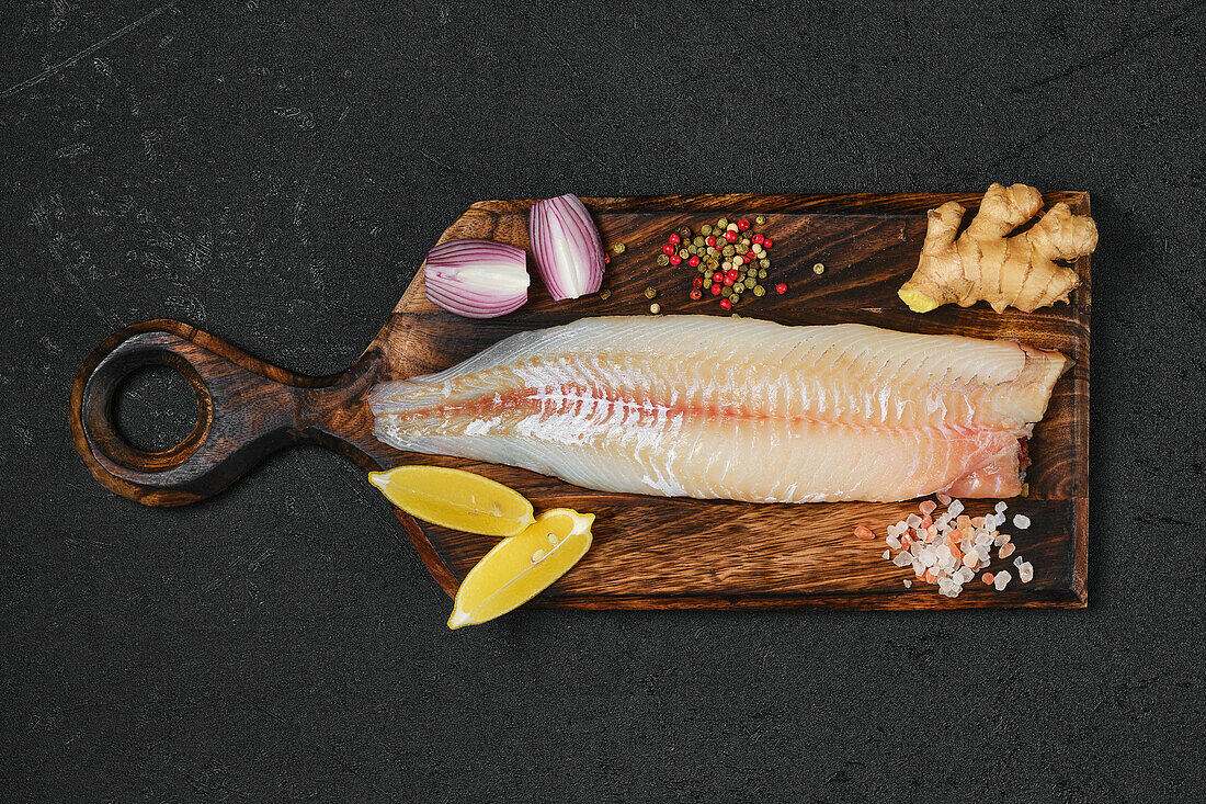 Raw pike-perch fillet on a wooden board