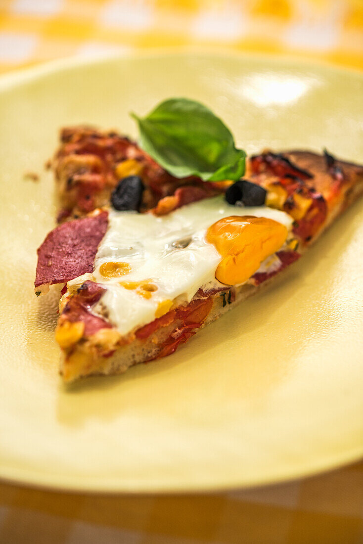 Pizza with fried egg and basil leaf