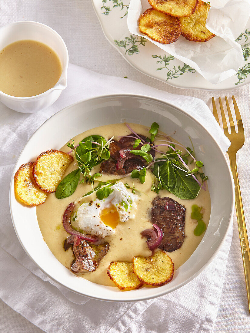 Liver with poached egg and fried potatoes in potato sauce