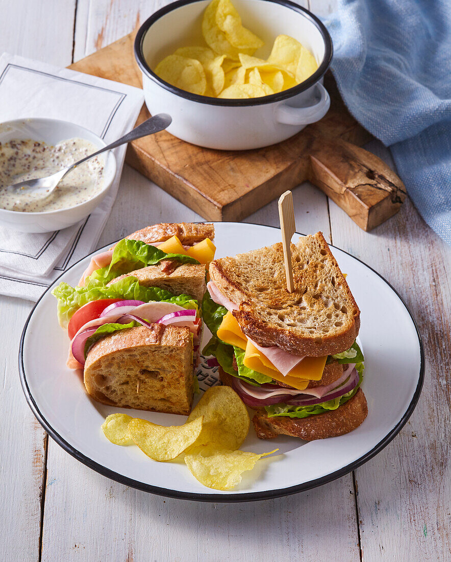 Ham and cheese sandwich with salad and crisps