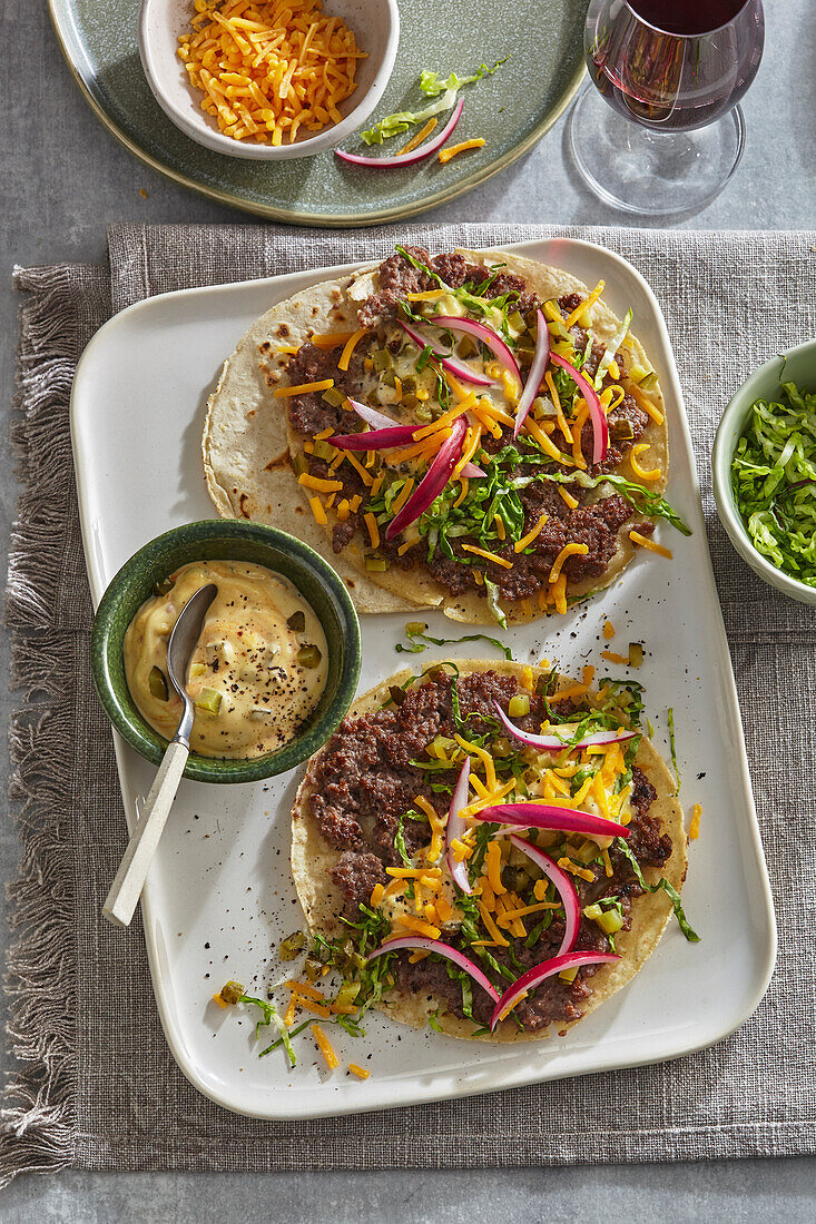 Open beef tacos with cheddar and vegetables