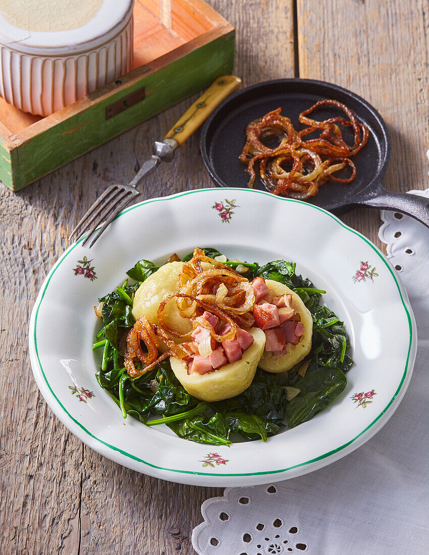 Potato dumplings filled with smoked pork on spinach