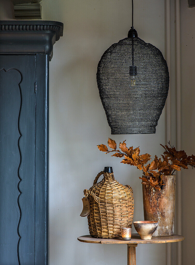 Table with autumnal decoration and lamp in a rustic room